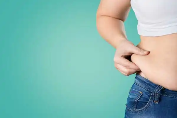 Image of woman pinching her love handles to show weight gain Stourbridge